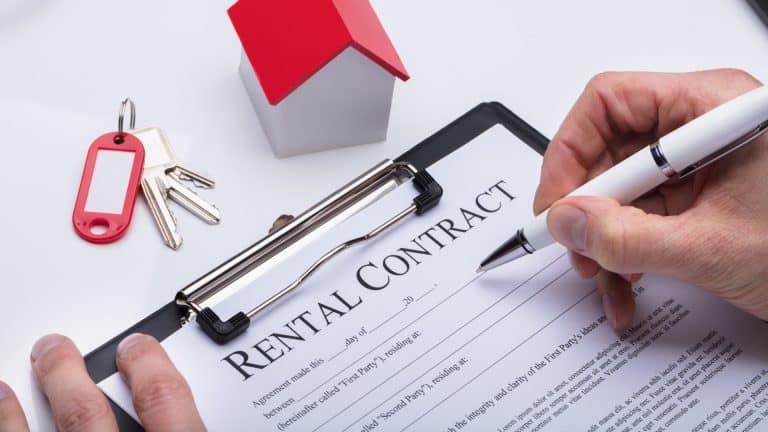 A person signing a rental contract on a clipboard.